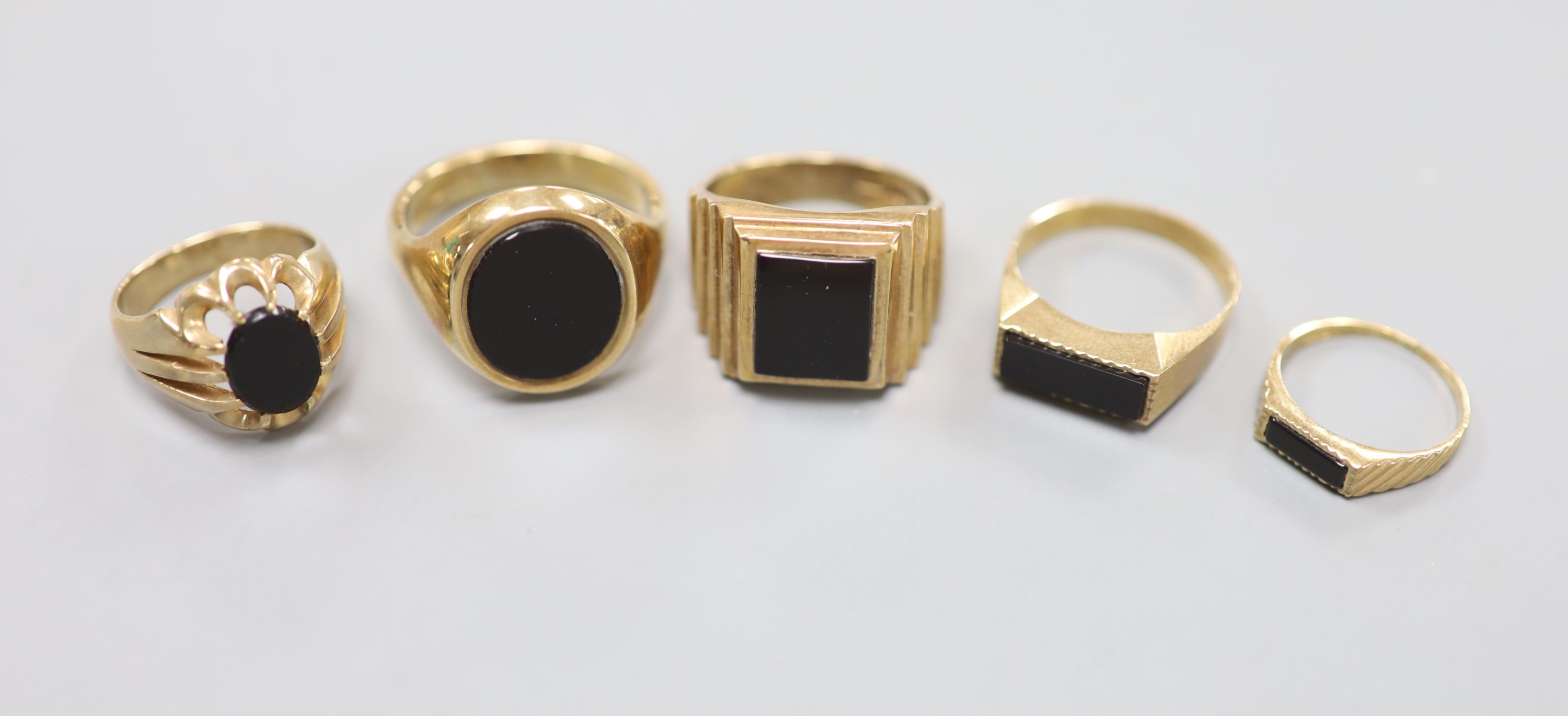Three assorted 9ct and black onyx signet rings and two other similar rings, largest size W
